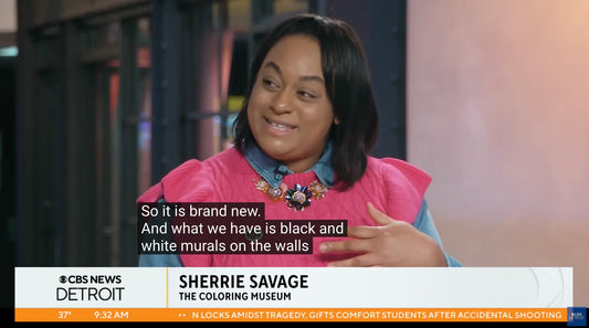 A person is speaking on a CBS News segment in Detroit. The text on the screen identifies them as Sherrie Savage, associated with The Coloring Museum. They are wearing a pink outfit and discussing black and white murals on walls. Captions are visible.