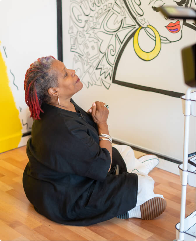 A woman sitting cross legged on the floor at  The Coloring Museum